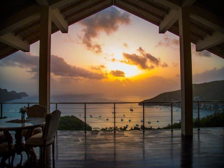Sunset view from Villa Morberg’s wide furnished terrace overlooking Admiralty Bay in Bequia, a luxury rental villa featured on the Real Grenadines website.
